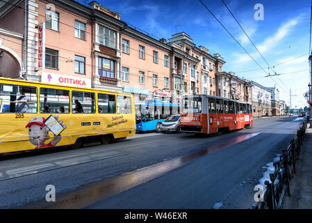 Irkutsk, Russia, Luglio 6, 2019. Tram e autobus con pubblicità passando sulla via Lenin Foto Stock