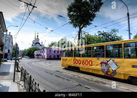Irkutsk, Russia, Luglio 6, 2019. Il tram con pubblicità passando vicino Harlampievskaya Michele Arcangelo Chiesa Foto Stock