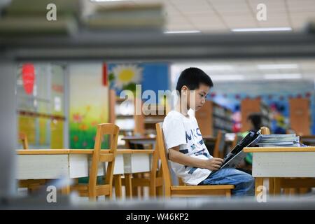 Hefei, cinese della provincia di Anhui. Il 20 luglio, 2019. Un ragazzo legge libri durante le vacanze estive a Anhui Biblioteca provinciale a Hefei, a est della capitale cinese della provincia di Anhui, 20 luglio 2019. Credito: Zhang Duan/Xinhua/Alamy Live News Foto Stock