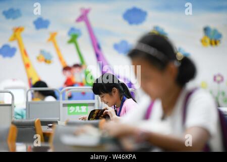 Hefei, cinese della provincia di Anhui. Il 20 luglio, 2019. Bambini letto libri durante le vacanze estive a Anhui Biblioteca provinciale a Hefei, a est della capitale cinese della provincia di Anhui, 20 luglio 2019. Credito: Zhang Duan/Xinhua/Alamy Live News Foto Stock