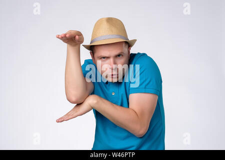 Funny Man in estate hat sollevamento palm come se conoscendo kung fu Foto Stock