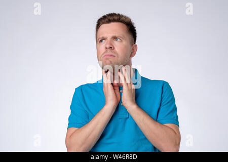 Giovane uomo nel controllo della sua linfonodo sulla gola Foto Stock