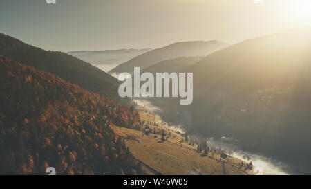 Alta Montagna Sunrise Foggy Gorge Vista aerea. Hill fondo villaggio di Campagna Vista panoramica. Natura selvaggia della silvicoltura morbida pendenza luce solare Eco Friendly ambiente Nozione Drone di volo Foto Stock