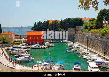 Piccolo porticciolo, barche legata, antica città di pietra a parete, Mare Adriatico, Dalmazia, Zadar, Croazia; Europa; estate, orizzontale Foto Stock