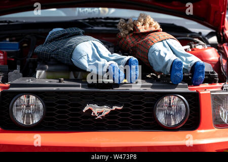 Hannover, Germania. Il 20 luglio, 2019. Due bambole giacciono nel vano motore di una Ford Mustang durante la strada Mag Show. Circa 2500 motorizzati auto classica dagli USA sono stati in mostra ad Hannover dal sabato. Credito: Peter Steffen/dpa/Alamy Live News Foto Stock