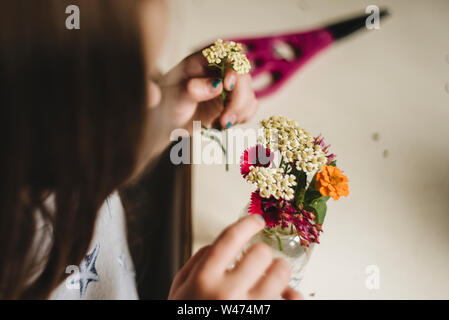 Bambina fa un mazzo di fiori in cucina Foto Stock