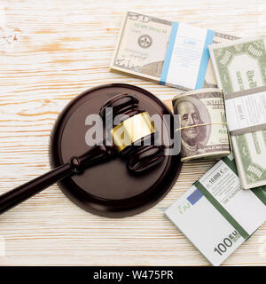 Vista superiore del giudice martello e pacchi di dollari e le banconote in euro su un bianco tavolo in legno.Il concetto di crescente debito nazionale- immagine Foto Stock