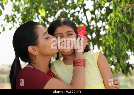 Donna baciare la figlia Foto Stock