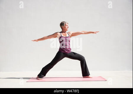 Coppia senior donna dolce practing Riparatoria Yoga pone fotografato in uno sfondo bianco. Foto Stock