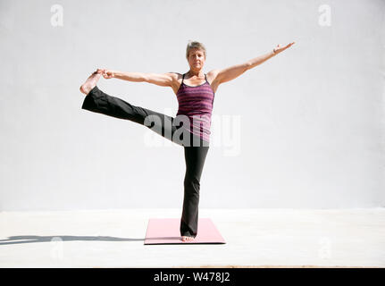 Coppia senior donna dolce practing Riparatoria Yoga pone fotografato in uno sfondo bianco. Foto Stock