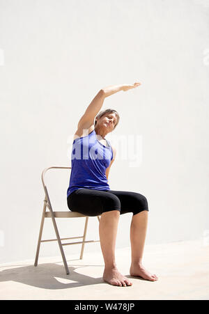 Coppia senior donna dolce practing Riparatoria Yoga pone fotografato in uno sfondo bianco. Foto Stock