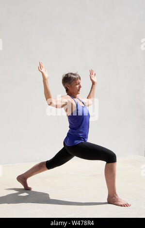 Coppia senior donna dolce practing Riparatoria Yoga pone fotografato in uno sfondo bianco. Foto Stock