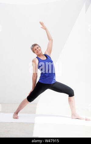 Coppia senior donna dolce practing Riparatoria Yoga pone fotografato in uno sfondo bianco. Foto Stock