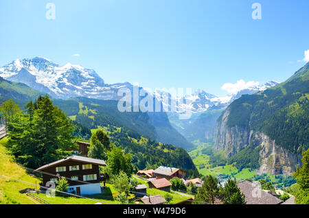 Il pittoresco villaggio alpino Wengen, Svizzera. Famoso Lauterbrunnen e Staubbach cade in background. Alpi svizzere con la neve sulla sommità. La Svizzera in estate. Paesaggio alpino. Foto Stock