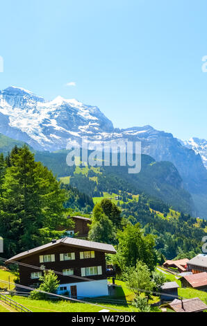 Incredibile villaggio di Wengen nelle Alpi Svizzere. Le creste della montagna con la neve sulla sommità in background. La Svizzera Estate. Paesaggio alpino. Chalet di montagna. Popolare resort. Luogo turistico. Foto Stock