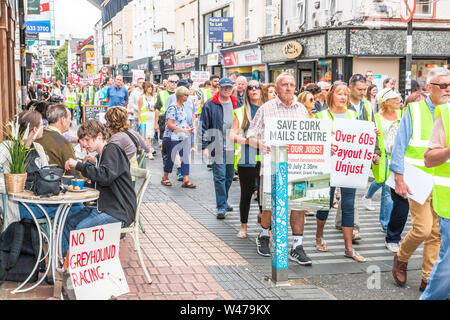 La città di Cork, Cork, Irlanda. Il 20 luglio, 2019. Ai lavoratori del settore postale marzo giù Oliver Plunkett Street per l'Ufficio Generale delle Poste in segno di protesta contro la proposta di chiusura da un post del suo centro di distribuzione nella piccola isola con la perdita di 250 posti di lavoro, sulle strade di Cork, Irlanda. -Credito; David Creedon / Alamy Live News Foto Stock