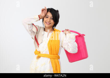 Donna che mantiene un cucchiaio e sorridente Foto Stock