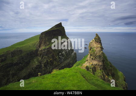 Scogliere sul mare di Isola Mykines, le isole Faerøer, in estate Foto Stock