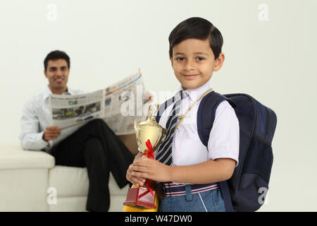 Ritratto di uno scolaro tenendo un trofeo Foto Stock