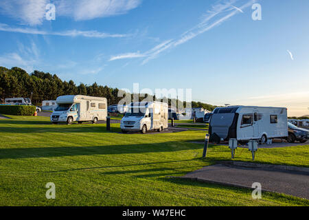 A tarda sera sun con camper e roulotte in un campeggio nel Galles del Nord Regno Unito Foto Stock