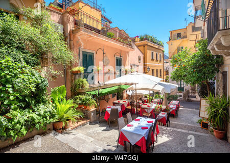 Coloratissima strada stretta con cafè nel centro storico di Taormina. Sicilia, Italia Foto Stock