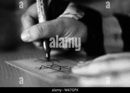 Persona scrittura e disegno in bianco e nero con grano Foto Stock