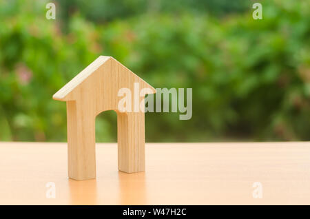 Figura in legno di una casa con una grande porta sulla natura dello sfondo. Home, abitazioni a prezzi accessibili, edificio residenziale. concetto di acquisto e di vendita di real Foto Stock