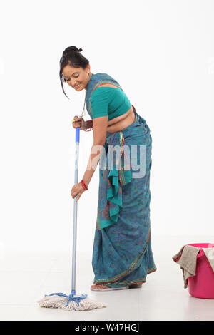 Donna tergi pavimento e sorridente Foto Stock