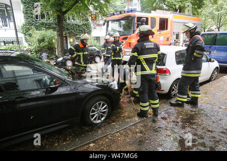 Amburgo, Germania. Il 20 luglio, 2019. Vigili del fuoco sollevare un chiusino durante un meteo-operazione correlata in modo che si accumula acqua piovana può defluire. Nel pomeriggio di sabato, un temporale hit anteriore Amburgo e Schleswig-Holstein. Credito: Bodo segna/dpa/Alamy Live News Foto Stock