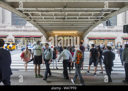 Persone attraversano 42nd Street nel e fuori dal Grand Central Terminal a Pershing Square con il Park Avenue ponte sopra. Foto Stock