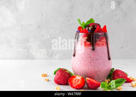 Una sana colazione deliziosa dessert. yogurt alla fragola o semi di chia il budino di cioccolato, frutti di bosco freschi e menta. close up Foto Stock