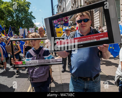 Londra, Regno Unito. Il 20 luglio 2019. Due dimostranti con schermi televisivi come migliaia marzo da Park Lane per un rally in piazza del Parlamento organizzata da gruppi di base per spingere il Regno Unito al fosso Brexit e Boris Johnson e soggiorno in Europa. Dicono sondaggio dopo sondaggio mostra che il pubblico dovrebbe votare ora restano e che il lasciare il caso era pieno di menzogne, con nessuno di votare per il tipo del disastroso no-deal Brexit che Johnson e i suoi sostenitori ora proporre e chiamata per un nuovo voto popolare. Il Regno Unito è ora un pro-paese UE e dovrebbe rimanere in piena adesione all'Unione europea per costruire un pulitore, più ecologici e più sicure e più equa la vita per tutti Foto Stock