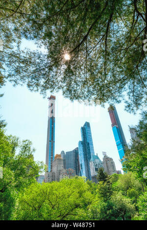 Skyline di Manhattan incorniciato dalla natura. Grattacieli, vista da Central Park. Giornata di sole a New York City Foto Stock