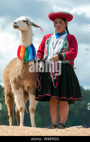 Una signora vestita di tradizionale Peruviano vestiti con la sua llama presso le antiche rovine di Sacsayhuaman vicino a Cusco in Perù. Foto Stock
