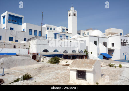 Tradizionale imbiancato minareto della moschea, e case residenziali nella medina della città turistica e sobborgo di Sidi Bou Said, Tunisi, Tunisia. Foto Stock