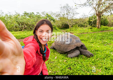 Avventura di viaggio turistico a isole Galapagos tenendo selfie phot da tartarughe giganti sull isola di Santa Cruz in Isole Galapagos. Gli animali e la natura in Galápagos highlands. Foto Stock