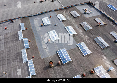 Grande fabbrica di tetto. Edificio adibito a magazzino in una zona industriale. Birds Eye view Foto Stock