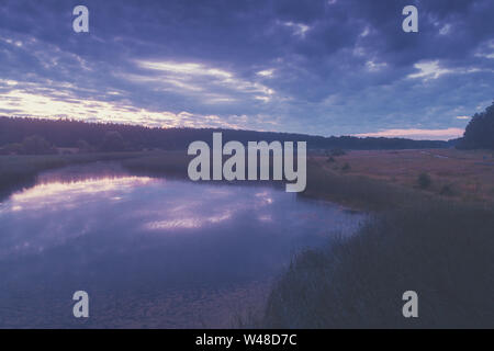 Magico tramonto in campagna. Paesaggio rurale in serata. Vista aerea del Lago Foto Stock