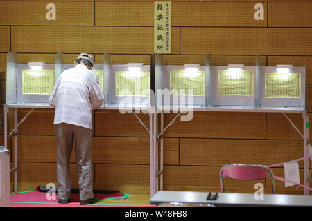 Tokyo, Giappone. 21 Luglio, 2019. Un elettore riempie il suo voto in corrispondenza di una stazione di polling in Tokyo, Giappone, 21 luglio 2019. Gli elettori attraverso il Giappone ha iniziato a colata le loro schede elettorali di domenica in upper house elezione, che dovrebbe essere un barometro della pubblica opinione sul Primo Ministro Shinzo Abe è di sei anni e mezzo di potenza. Credito: Du Natalino/Xinhua/Alamy Live News Foto Stock