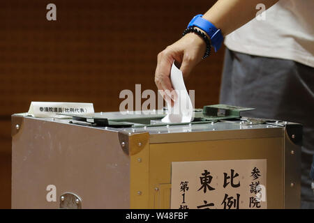 Tokyo, Giappone. 21 Luglio, 2019. Un elettore getta il ballottaggio in corrispondenza di una stazione di polling in Tokyo, Giappone, 21 luglio 2019. Gli elettori attraverso il Giappone ha iniziato a colata le loro schede elettorali di domenica in upper house elezione, che dovrebbe essere un barometro della pubblica opinione sul Primo Ministro Shinzo Abe è di sei anni e mezzo di potenza. Credito: Du Natalino/Xinhua/Alamy Live News Foto Stock