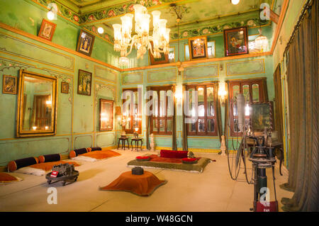 Aipur, Rajasthan, India - circa 2017: Verde sala murata con un lampadario, le luci e la massa posti a sedere per royalty in Udaipur city palace. Questi vecchi maj Foto Stock