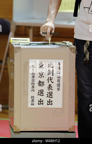 Tokyo, Giappone. 21 Luglio, 2019. Un elettore getta il ballottaggio in corrispondenza di una stazione di polling in Tokyo, Giappone, 21 luglio 2019. Gli elettori attraverso il Giappone ha iniziato a colata le loro schede elettorali di domenica in upper house elezione, che dovrebbe essere un barometro della pubblica opinione sul Primo Ministro Shinzo Abe è di sei anni e mezzo di potenza. Credito: Du Natalino/Xinhua/Alamy Live News Foto Stock