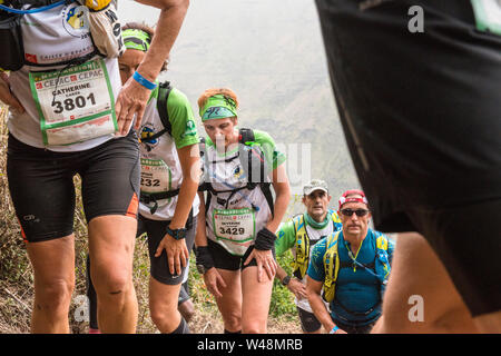 Stanco delle guide di scorrimento nel sensore pioggia, arrampicata al di fuori di un cratere sulla ripida traccia approssimativa da les deux Bras nel Cirque de Mafate durante il Grand Raid, Reunion Foto Stock