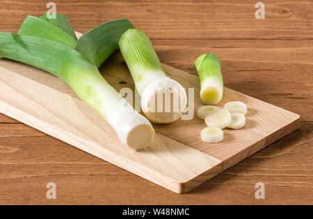 Alcuni i porri tagliati a fettine su sfondo di legno. Foto Stock