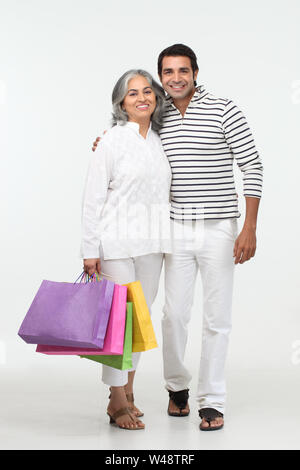 Donna anziana che porta borse per la spesa con suo figlio e sorridente Foto  stock - Alamy