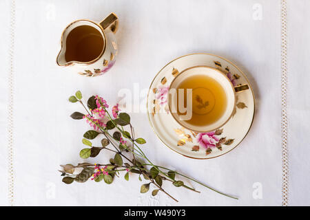 Tea time con fiori su un tavolo bianco panno Foto Stock