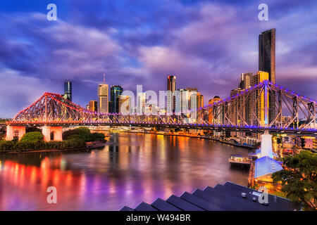 Bright lighs di Story Bridge nella città di Brisbane attraverso fiume Brisbane di fronte alle alte torri, CBD. Pre-sunrise immagine con la riflessione di illuminati Foto Stock