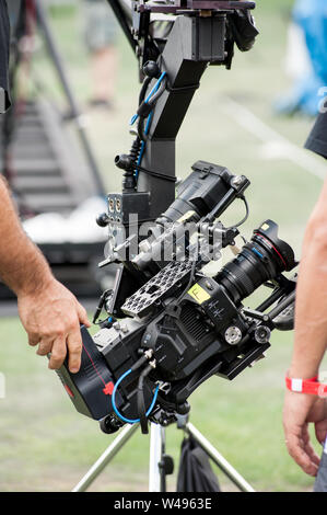 Fotocamera tecnica gli operatori impostano videocamera professionale su una grande gru a braccio, prima di sparare. Foto Stock