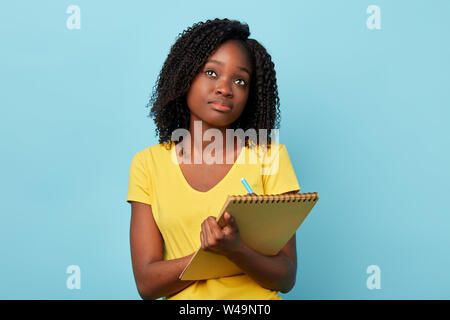 Considerato occupato concentrato bella donna con notepad guardando in alto, che compongono il piano, idea, la scrittura di una storia, poesia,rendendo note il concetto di creatività.clos Foto Stock