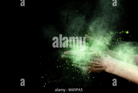 Esplosione di colore giallo di holi colore all'interno di polvere battendo le mani Foto Stock